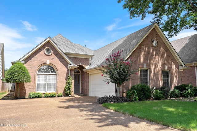 view of property with a garage and a front lawn