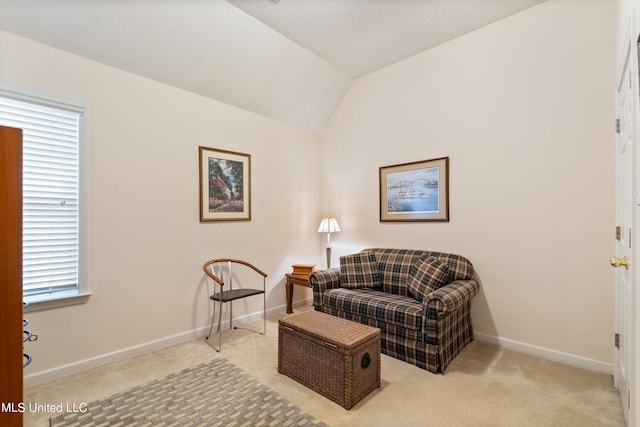 living area featuring light colored carpet, a wealth of natural light, and vaulted ceiling