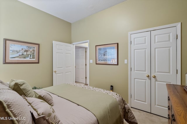 bedroom with light carpet and a closet