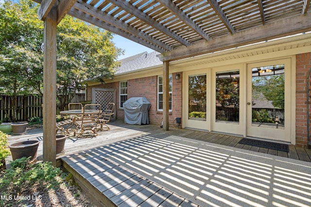 view of patio featuring a wooden deck, grilling area, and a pergola