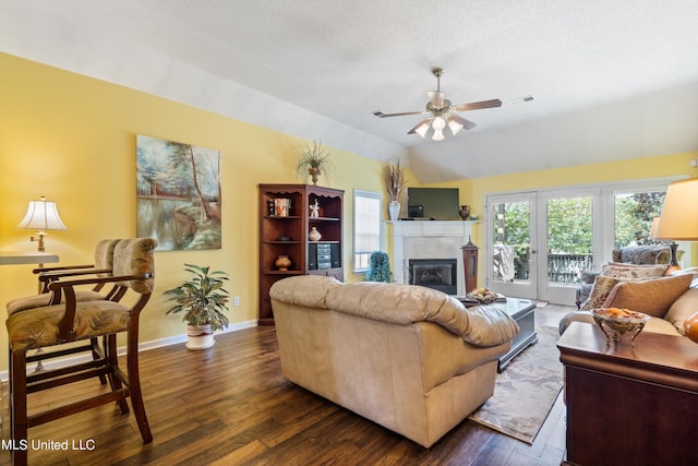 living room featuring lofted ceiling, a textured ceiling, dark wood-type flooring, and ceiling fan