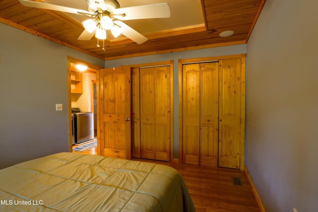 unfurnished bedroom with multiple closets, separate washer and dryer, dark hardwood / wood-style floors, and wood ceiling