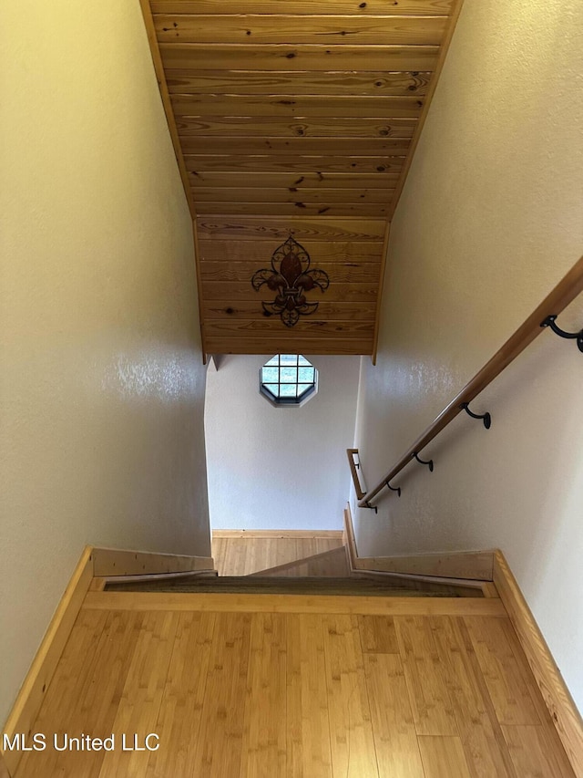 staircase featuring hardwood / wood-style floors and wooden ceiling