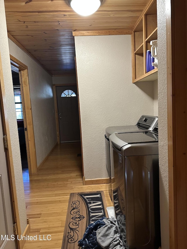 laundry area featuring wood ceiling, washing machine and dryer, and light wood-type flooring