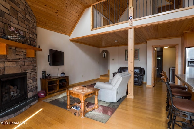 living room with high vaulted ceiling, wood ceiling, a fireplace, and light hardwood / wood-style floors