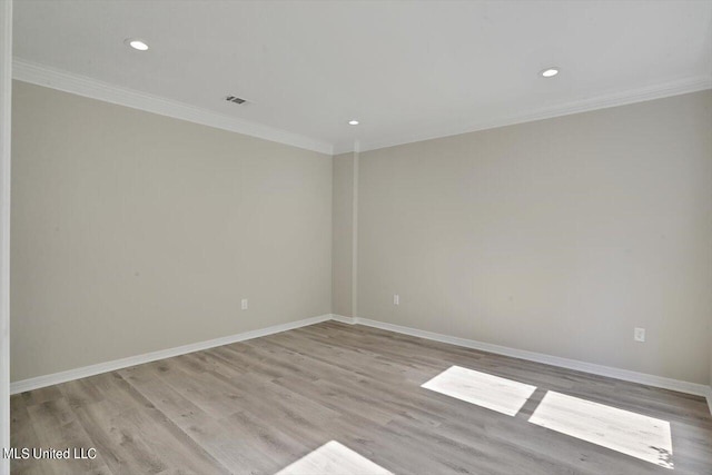 empty room featuring light hardwood / wood-style flooring and crown molding