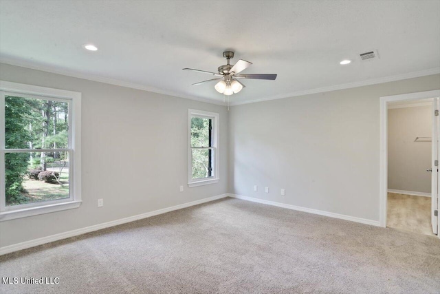 carpeted spare room featuring ceiling fan and crown molding