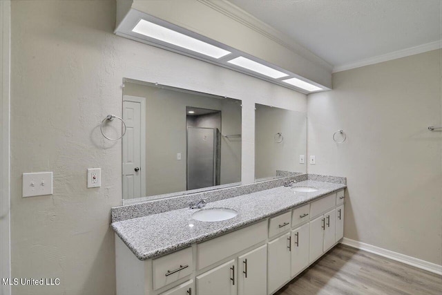 bathroom with vanity, ornamental molding, and hardwood / wood-style flooring