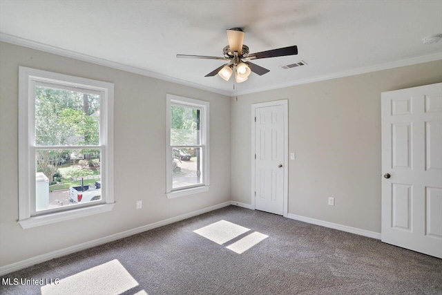 spare room with crown molding, carpet flooring, and ceiling fan