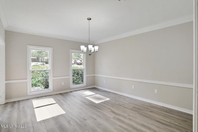 unfurnished room with a chandelier, crown molding, and light wood-type flooring