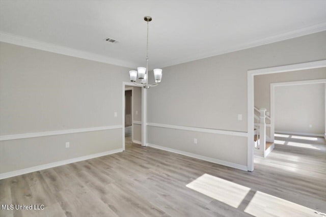 spare room with light hardwood / wood-style floors, a notable chandelier, and ornamental molding