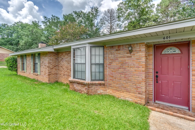 doorway to property featuring a yard