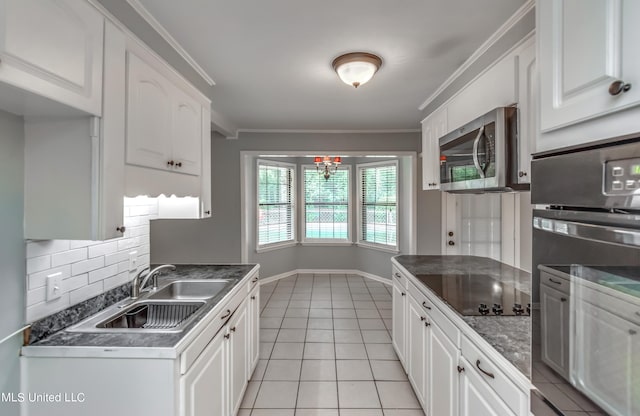 kitchen featuring backsplash, white cabinetry, ornamental molding, sink, and stainless steel appliances