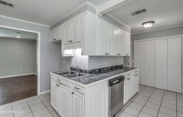 kitchen featuring stainless steel dishwasher, sink, and white cabinetry