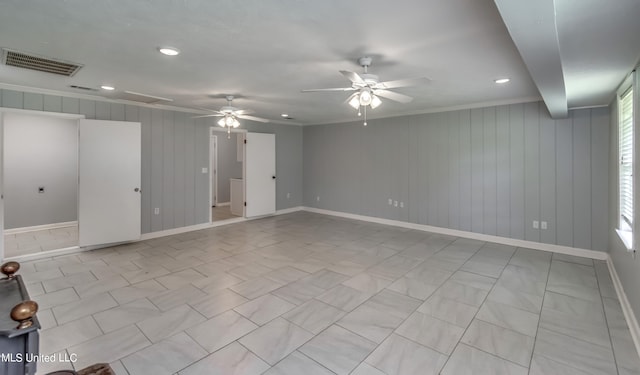 unfurnished room with ornamental molding, wooden walls, and ceiling fan