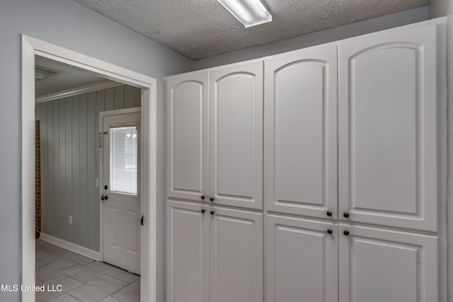 interior details with wood walls and a textured ceiling