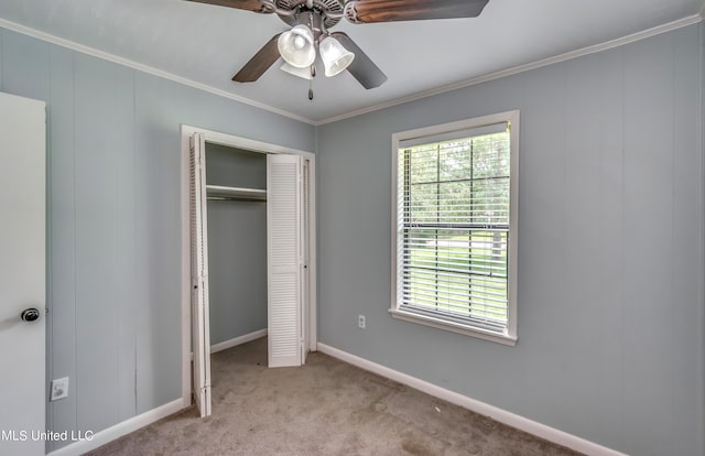 unfurnished bedroom featuring ornamental molding, light colored carpet, a closet, and ceiling fan