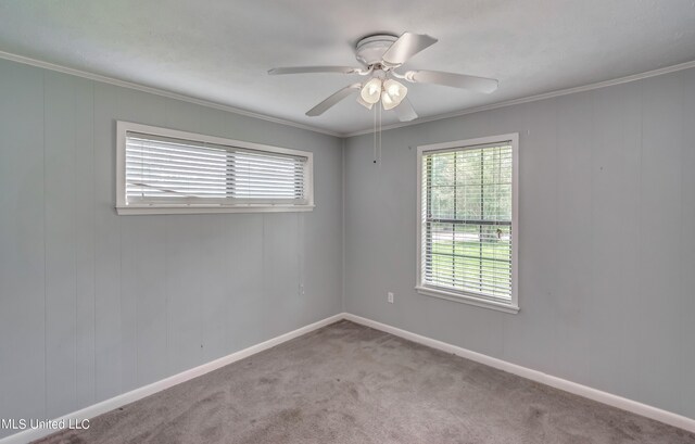 carpeted spare room with ornamental molding and ceiling fan