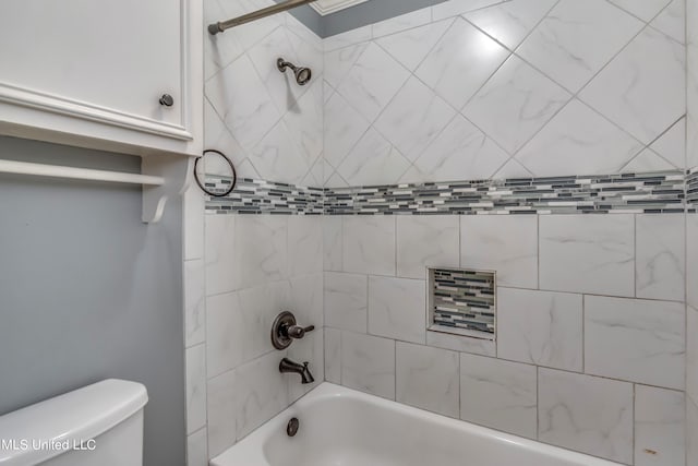 bathroom with tiled shower / bath and toilet