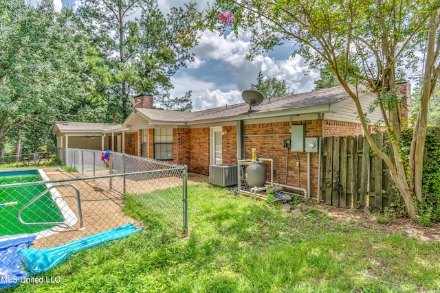 back of house with a swimming pool, central air condition unit, and a patio area