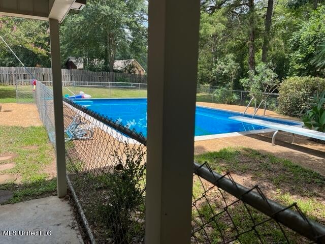 view of swimming pool featuring a diving board