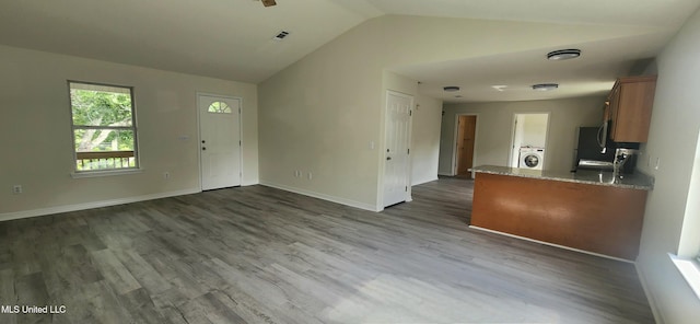 2708 Canty St, Pascagoula, MS 39567 - unfurnished living room with washer / clothes dryer, vaulted ceiling, and dark wood-type flooring