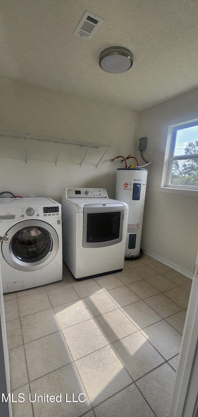 2708 Canty St, Pascagoula, MS 39567 - laundry room with water heater, independent washer and dryer, and light tile patterned floors