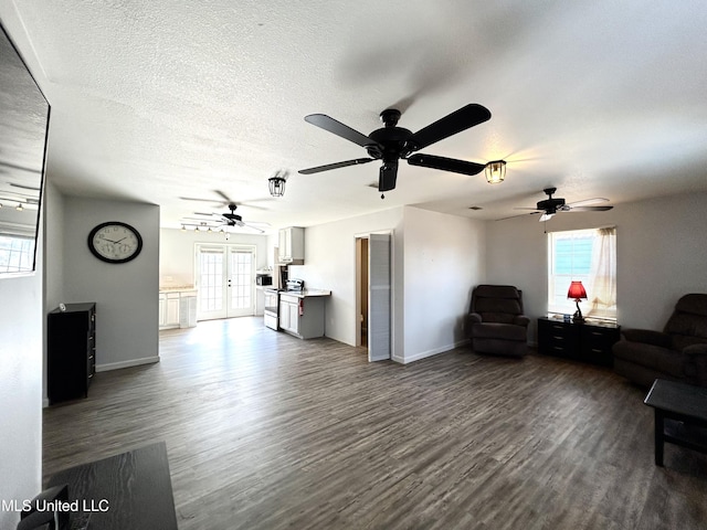 living room with french doors, dark hardwood / wood-style floors, and a textured ceiling