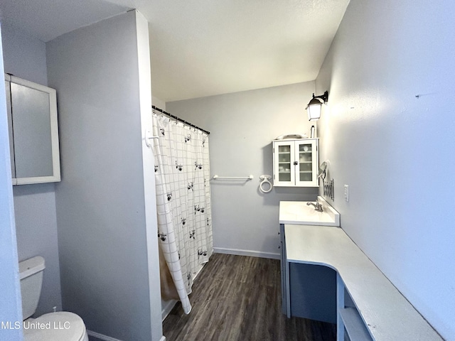 bathroom featuring curtained shower, hardwood / wood-style floors, toilet, and vanity