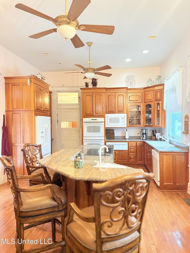 5 Spruce St, Oakland, MS 38948 - kitchen featuring white appliances, a breakfast bar area, glass insert cabinets, and light wood finished floors