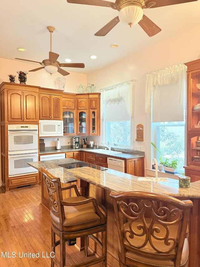 5 Spruce St, Oakland, MS 38948 - kitchen with glass insert cabinets, white appliances, brown cabinetry, and light stone countertops