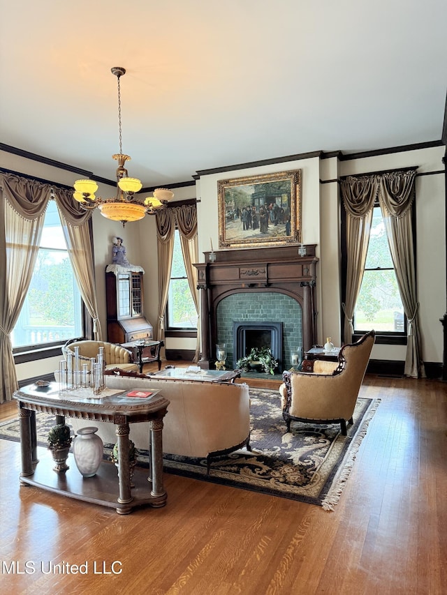 5 Spruce St, Oakland, MS 38948 - living area with a fireplace, a healthy amount of sunlight, wood finished floors, and ornamental molding
