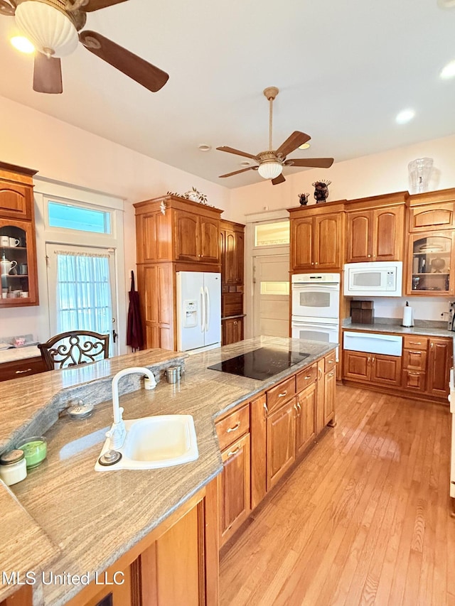 5 Spruce St, Oakland, MS 38948 - kitchen featuring a sink, white appliances, light wood finished floors, glass insert cabinets, and light stone countertops
