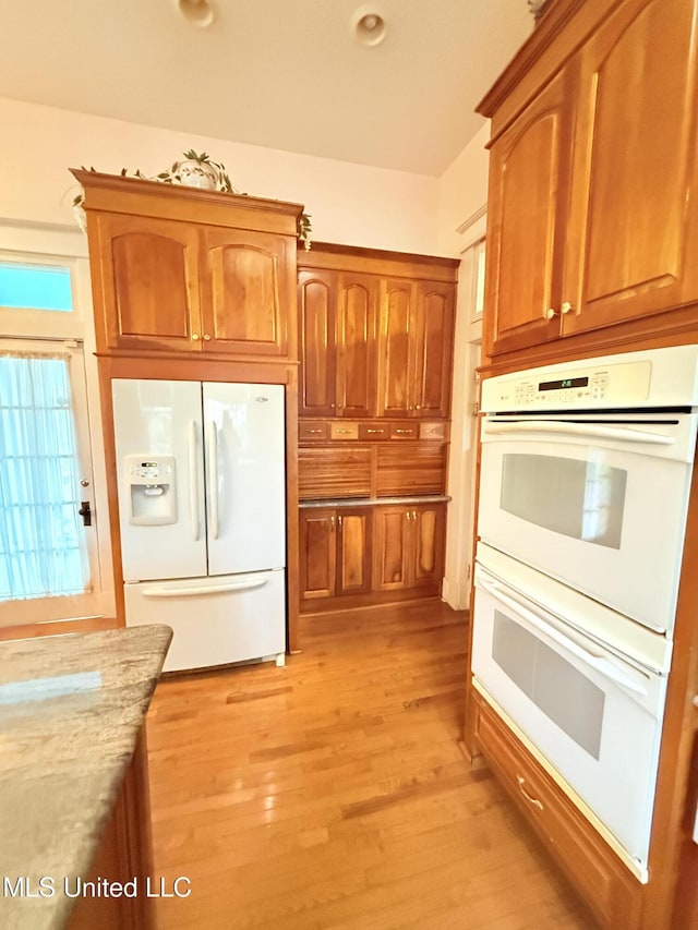 5 Spruce St, Oakland, MS 38948 - kitchen with brown cabinets, white appliances, light wood-style floors, and light stone countertops