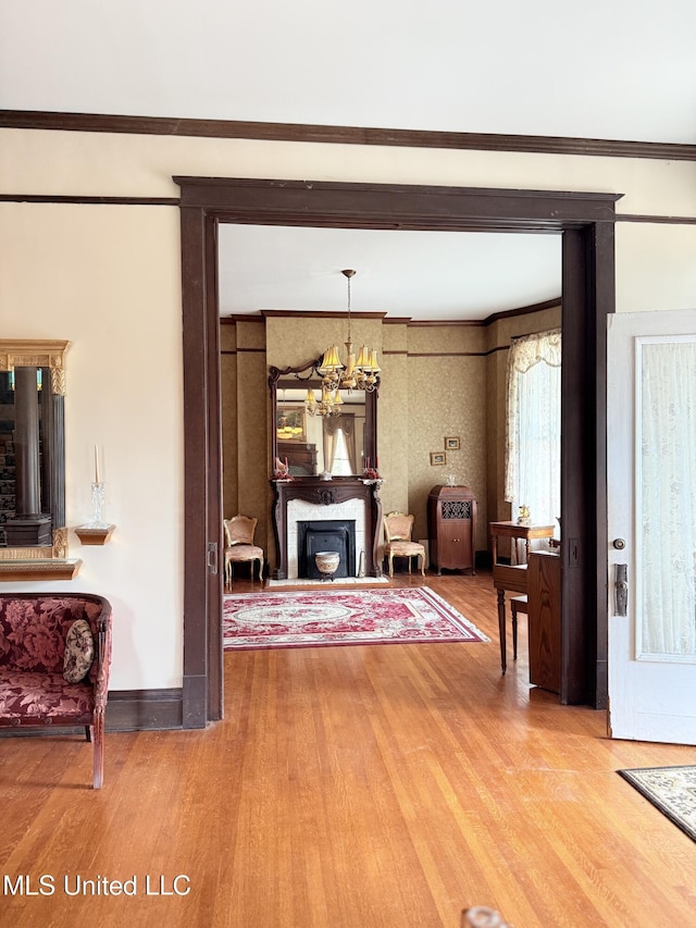 5 Spruce St, Oakland, MS 38948 - living area featuring wood finished floors, an inviting chandelier, a fireplace, crown molding, and baseboards