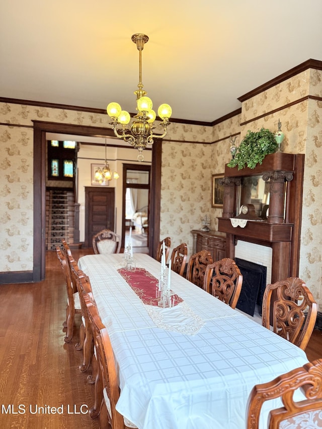 5 Spruce St, Oakland, MS 38948 - dining area with wallpapered walls, a chandelier, ornamental molding, a fireplace, and wood finished floors
