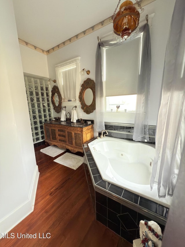 5 Spruce St, Oakland, MS 38948 - bathroom featuring double vanity, a whirlpool tub, and wood finished floors
