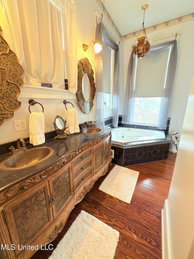 5 Spruce St, Oakland, MS 38948 - bathroom featuring double vanity, wood finished floors, a garden tub, and a sink