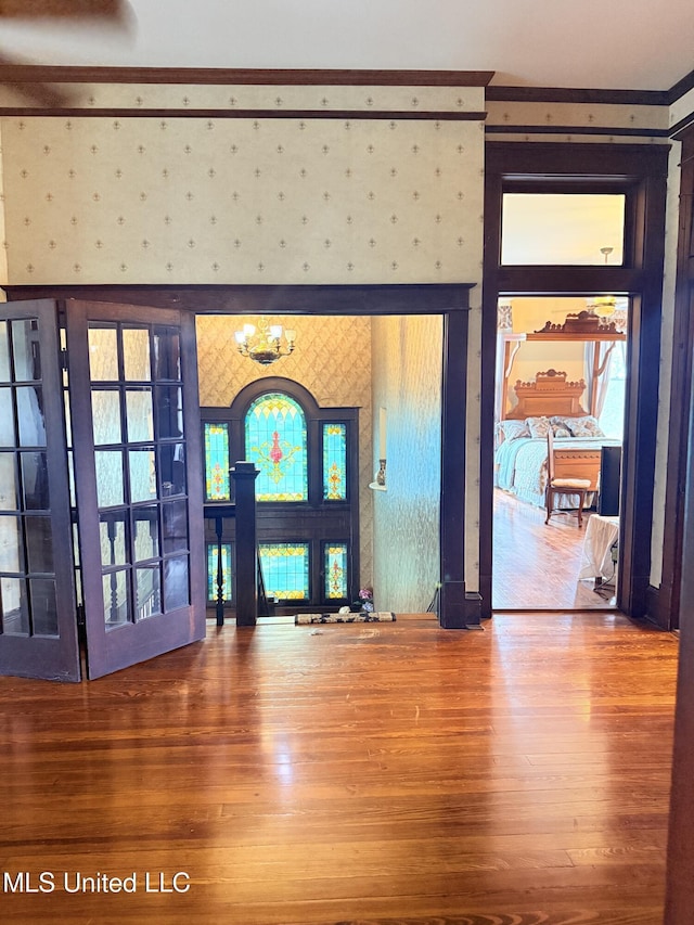 5 Spruce St, Oakland, MS 38948 - entryway with wallpapered walls, an inviting chandelier, wood finished floors, and a fireplace