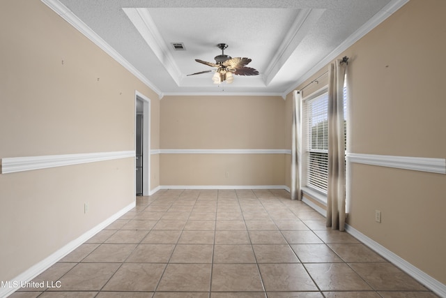 unfurnished room with ornamental molding, light tile patterned floors, ceiling fan, a raised ceiling, and a textured ceiling