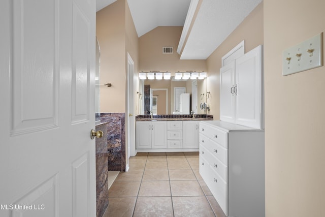 bathroom featuring vanity, vaulted ceiling, and tile patterned floors