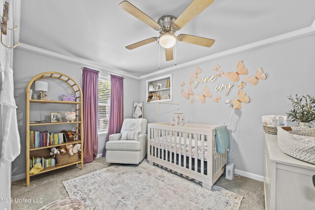 carpeted bedroom with ornamental molding, a nursery area, and ceiling fan