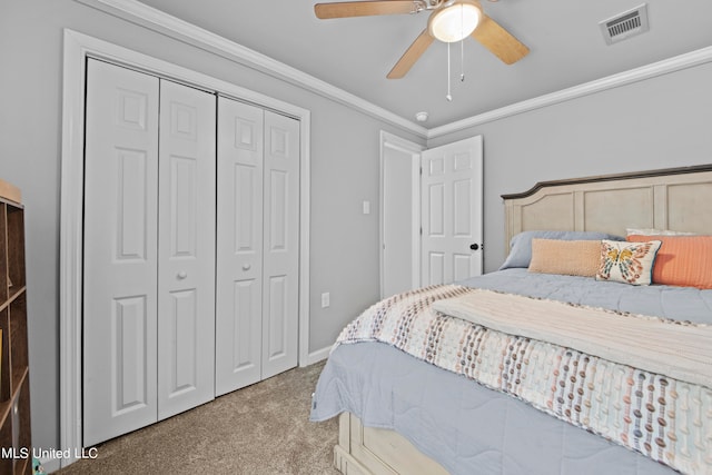 carpeted bedroom with a closet, ornamental molding, and ceiling fan