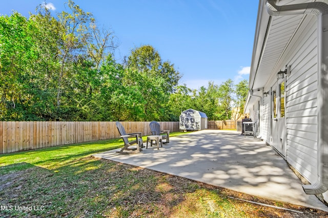 view of yard featuring a patio and a storage unit