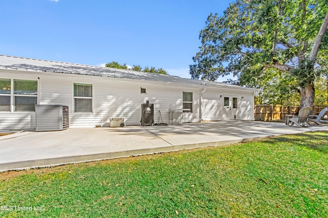 back of property with a patio area and a lawn