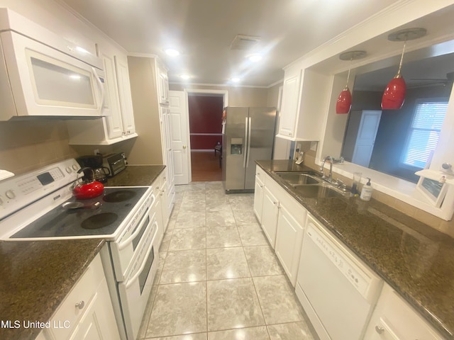 kitchen featuring white appliances, white cabinetry, a sink, and decorative light fixtures