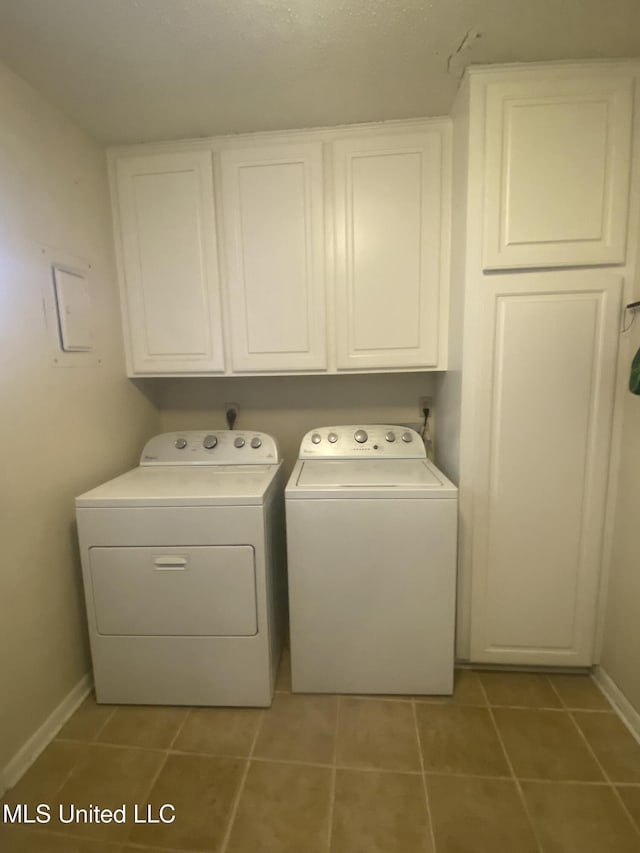 laundry room with cabinet space, tile patterned flooring, baseboards, and separate washer and dryer