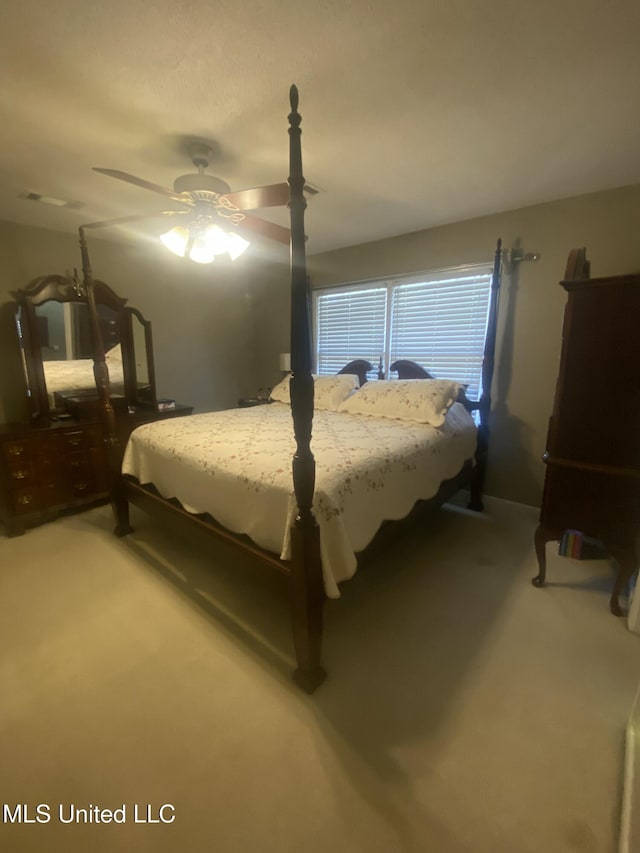 bedroom with a ceiling fan and light carpet