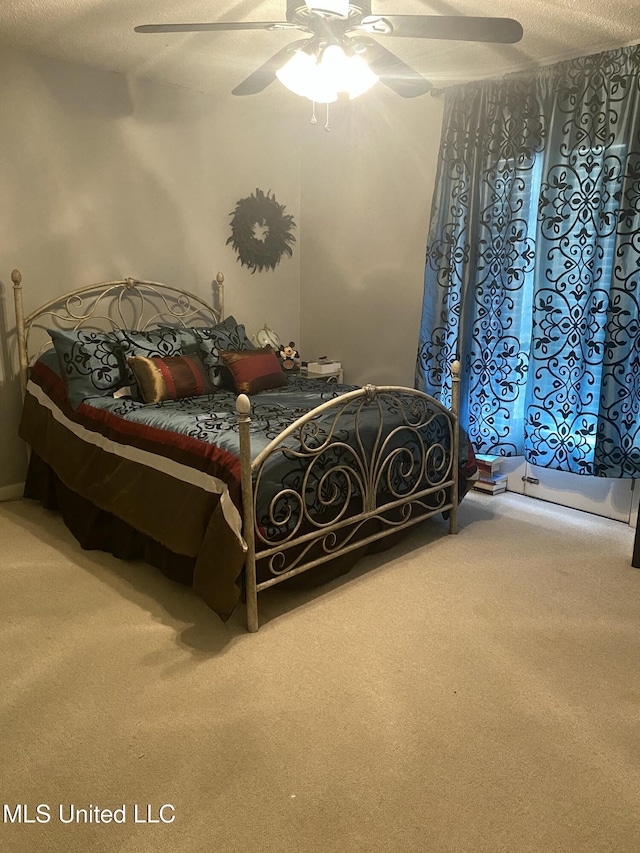 carpeted bedroom with ceiling fan and a textured ceiling