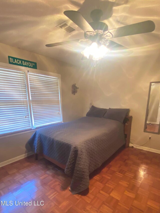 bedroom with ceiling fan, visible vents, and baseboards